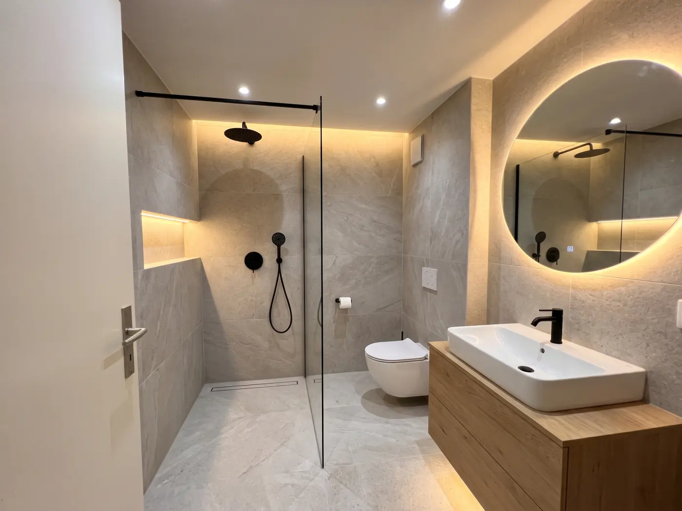 Dasselbe Bad nach der Sanierung mit bodengleicher Dusche und Waschtisch aus Eiche