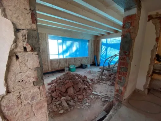 Entkerntes Mauerwerk mit freigelegtem Ziegel und Wanddurchbruch