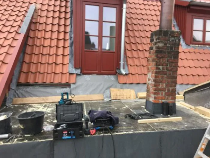 Dacharbeiten mit Schornstein und Werkzeug