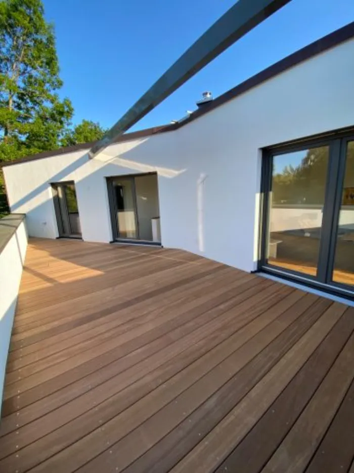 Holzterrasse vor bodentiefen Fenstern